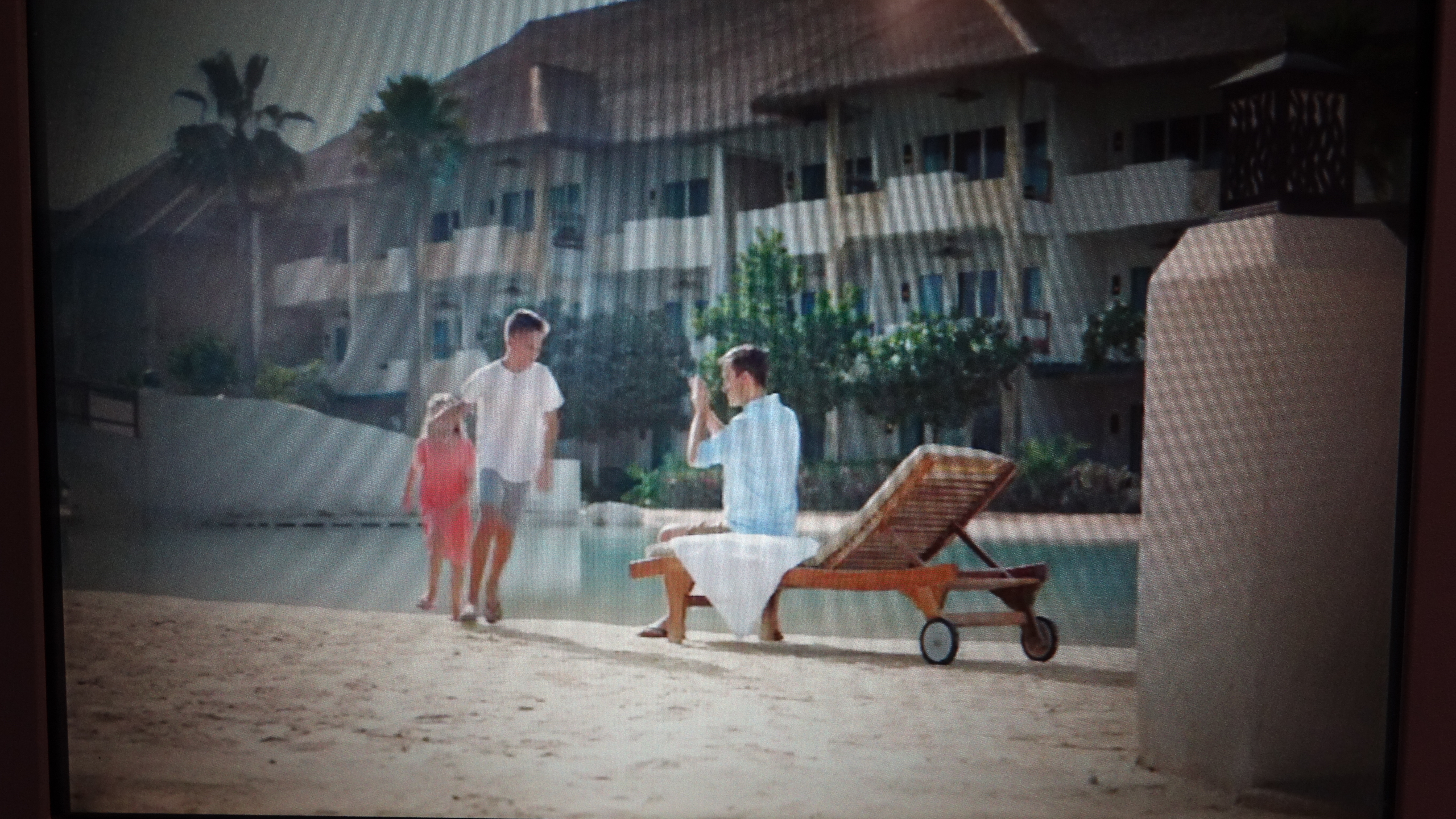 a man sitting on a chair next to a man and a child