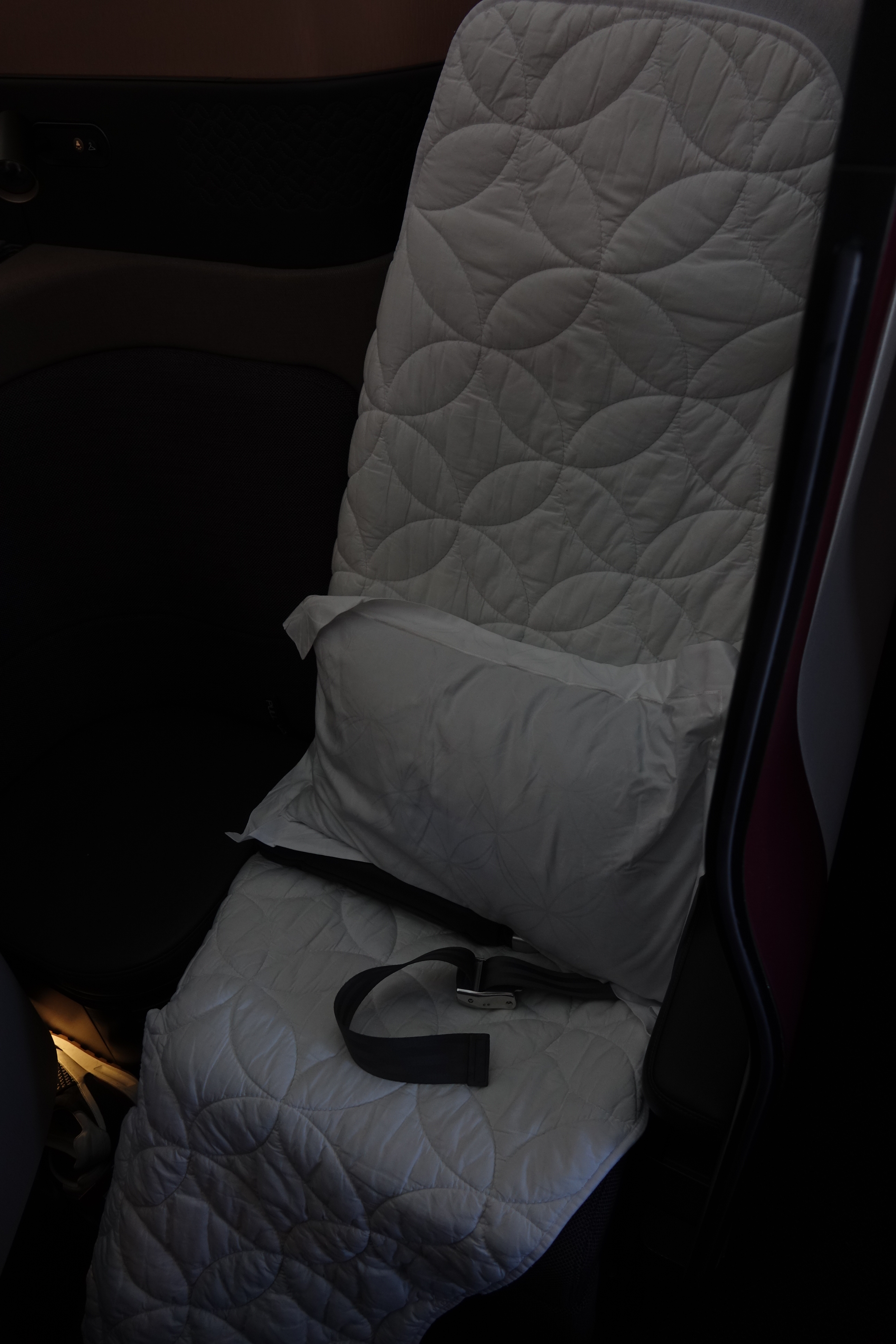 a seat with a pillow and a seat belt