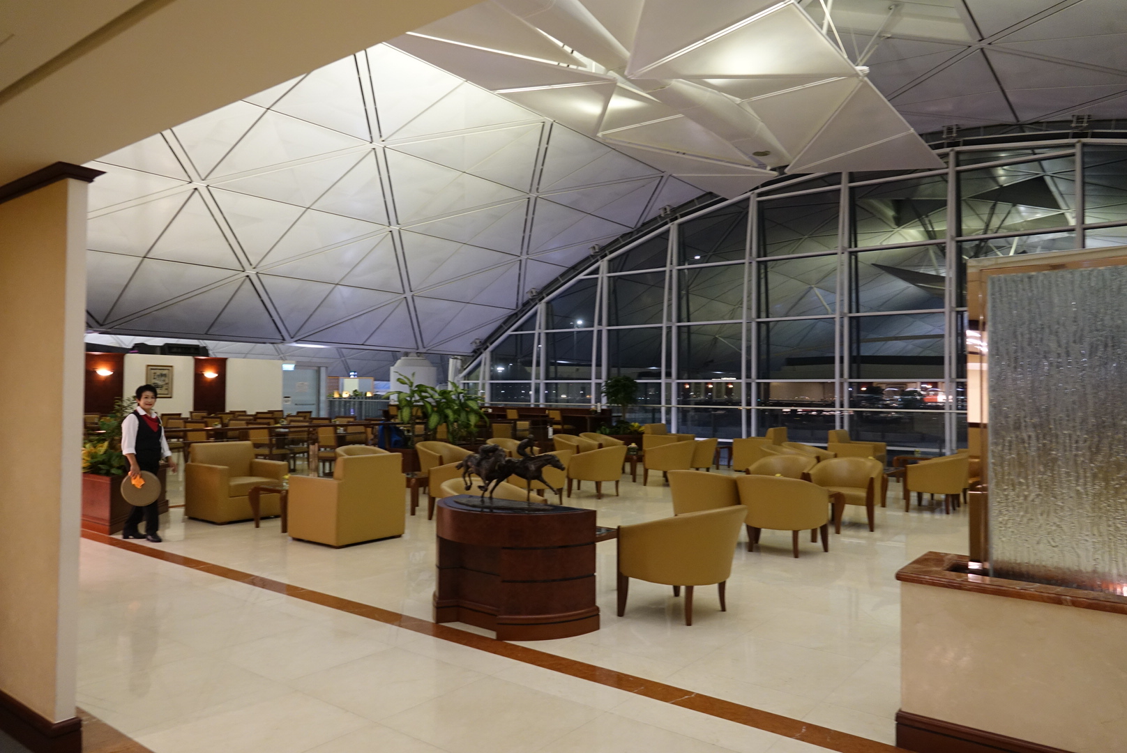 a room with a large glass ceiling and a statue of a horse on a table