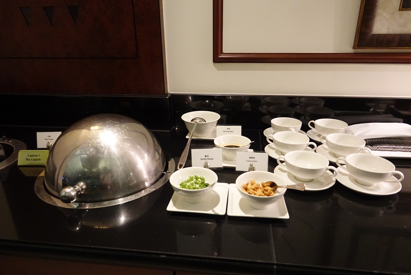 a group of white cups and saucers on a black counter