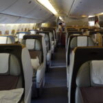 the inside of an airplane with people standing in the back