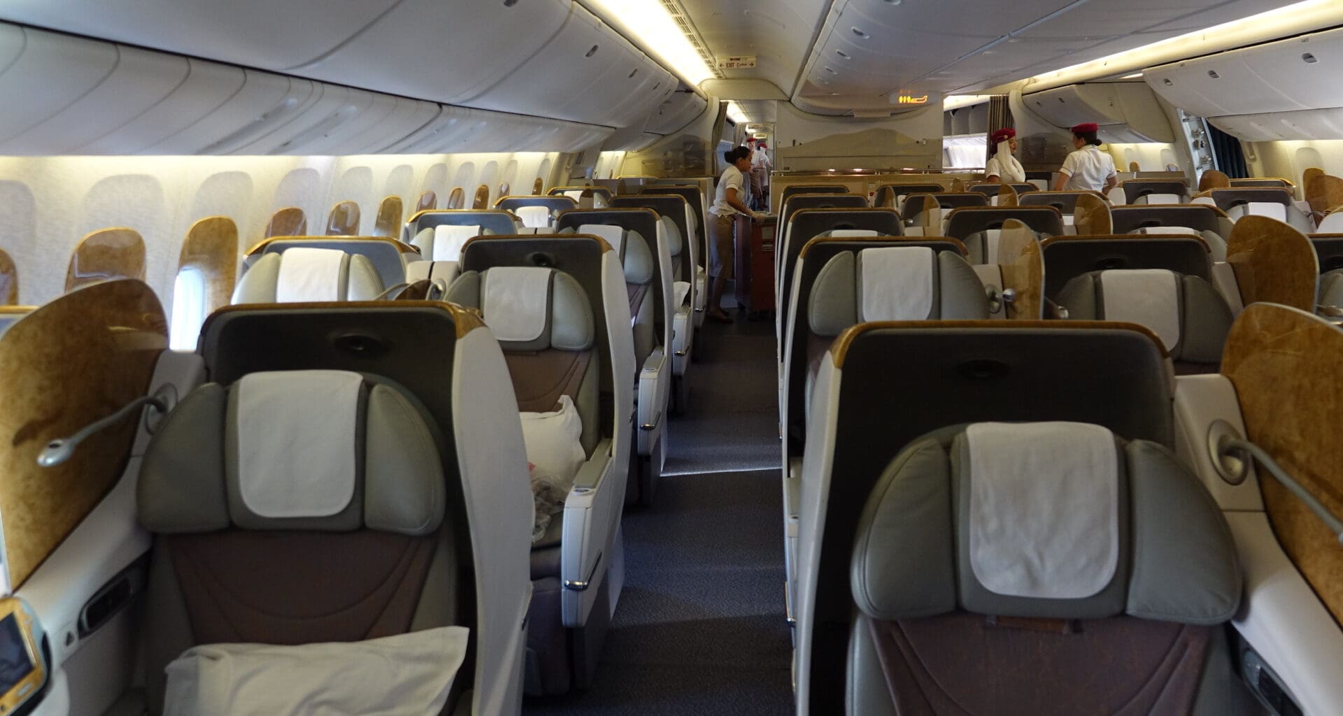 the inside of an airplane with people standing in the back