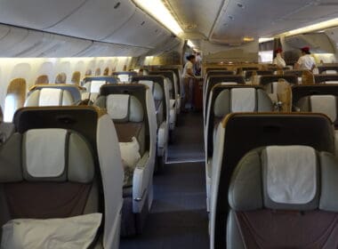 the inside of an airplane with people standing in the back