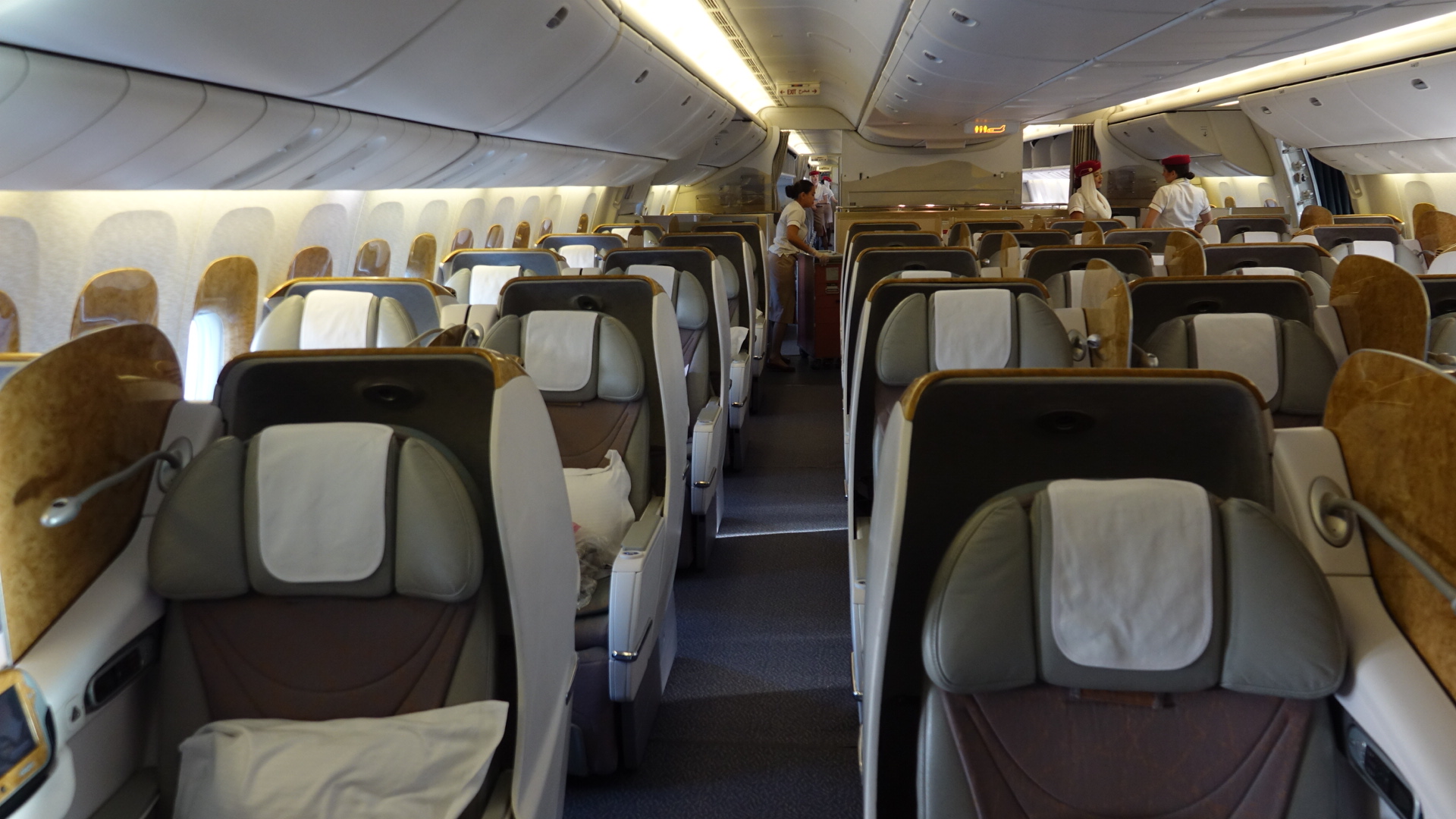 the inside of an airplane with people standing in the back