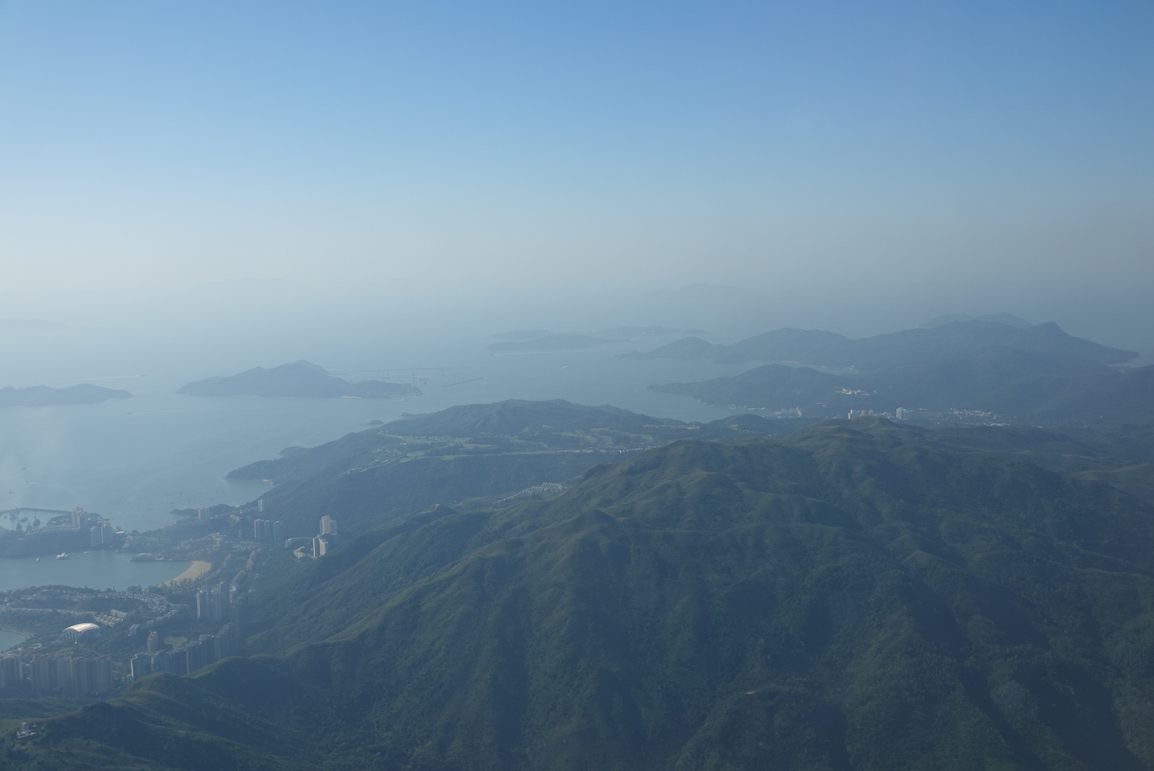 a view of a city and the ocean from a mountain