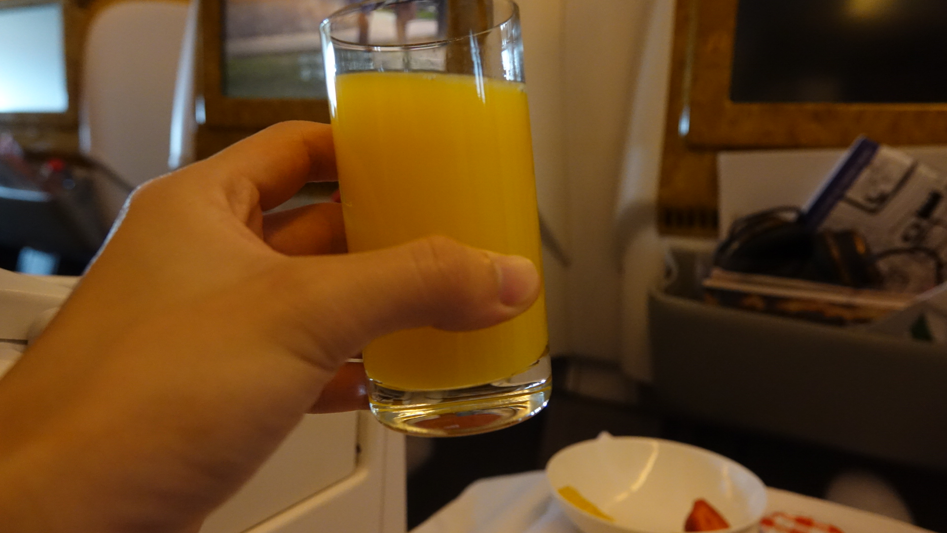 a hand holding a glass of orange juice