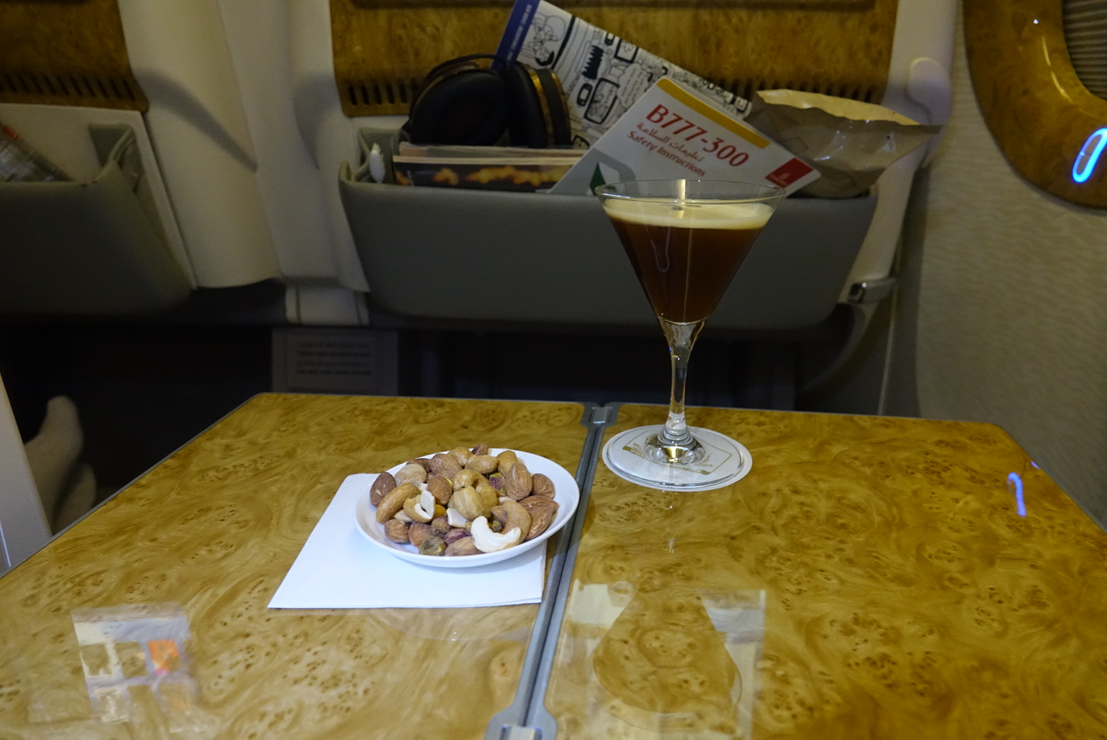 a glass of coffee and nuts on a table