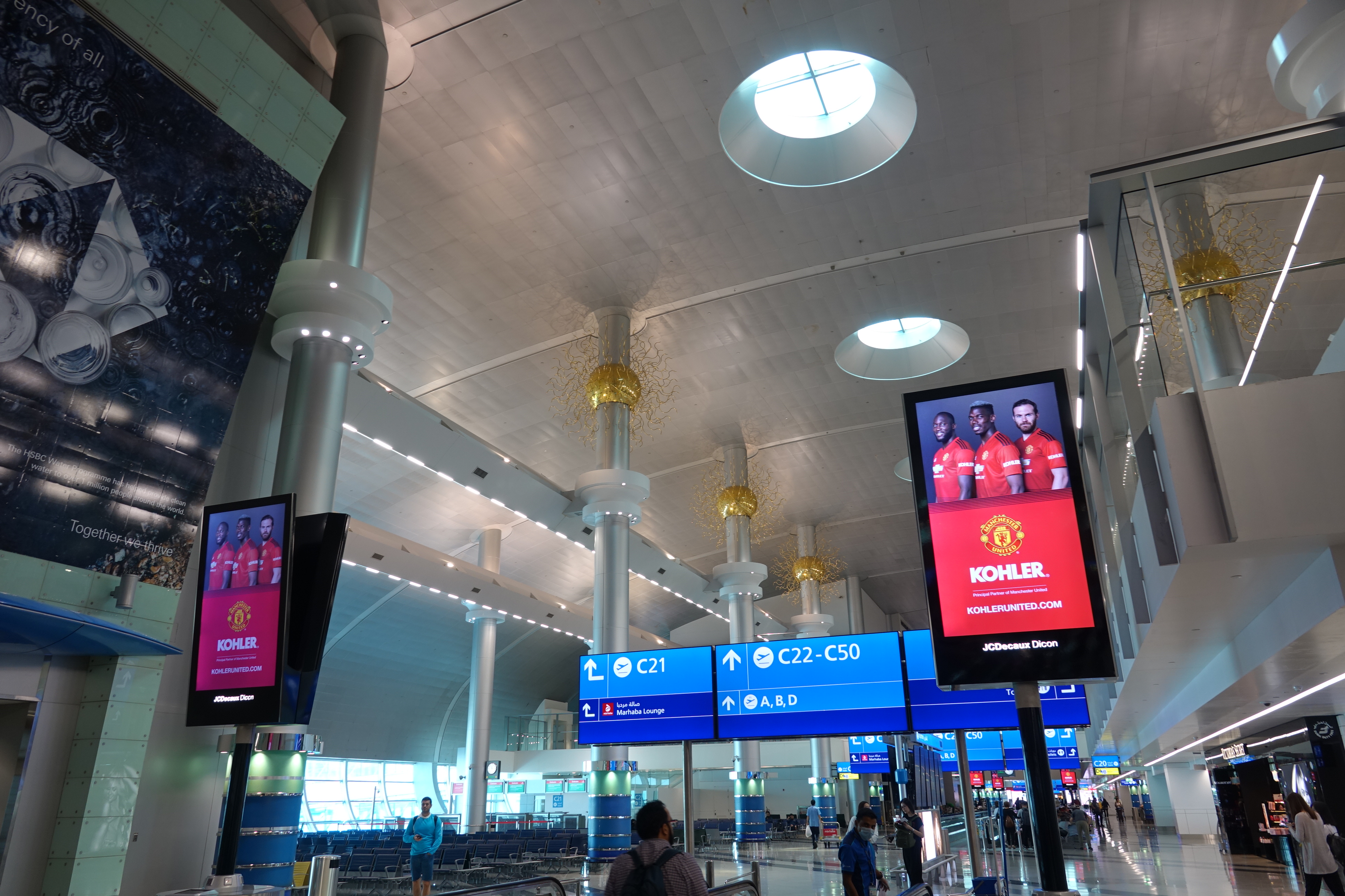 a large airport with blue signs and people walking