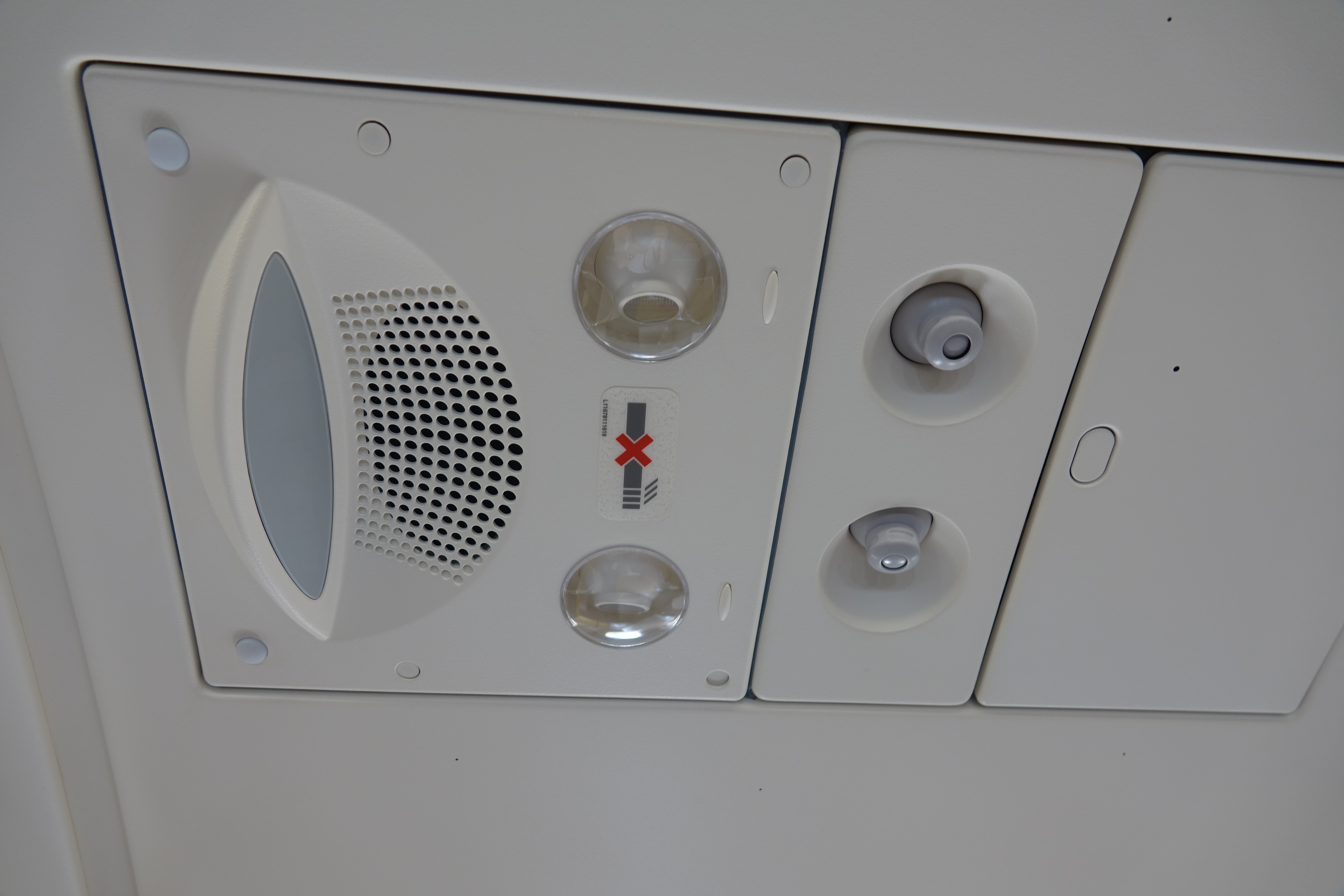 a white ceiling with a speaker and a red x