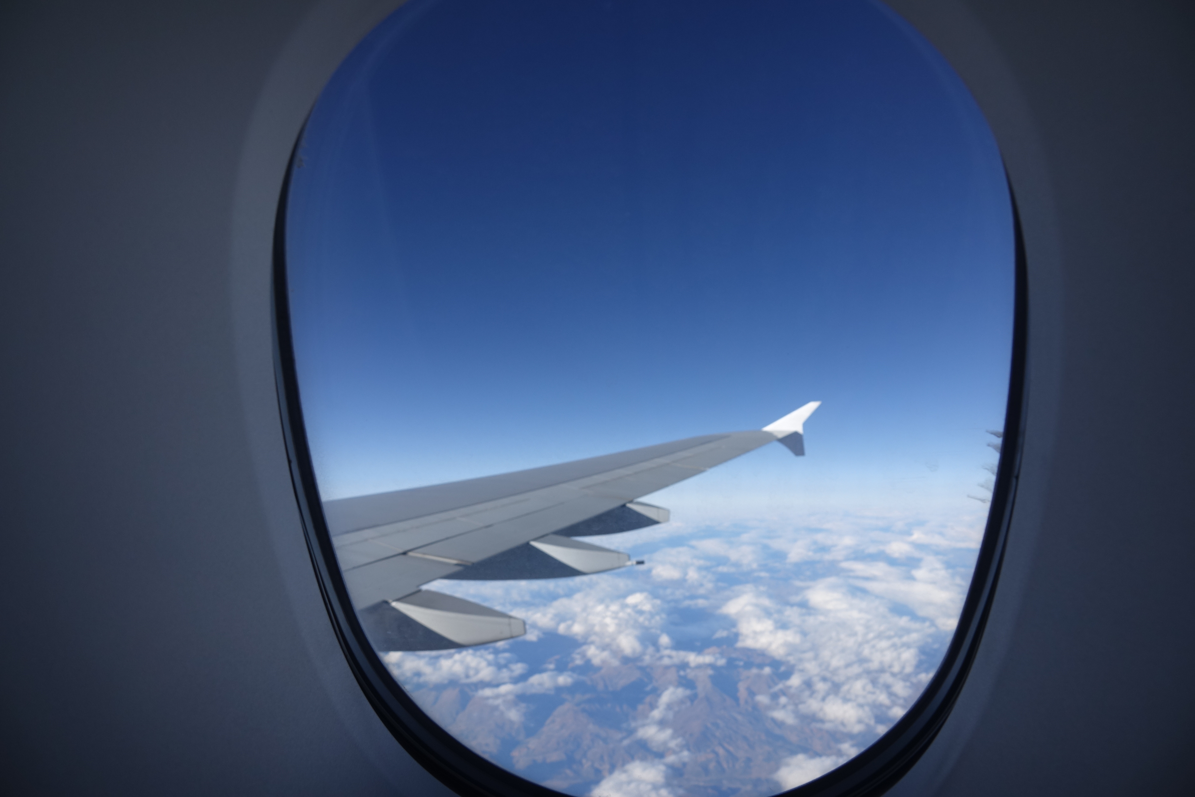 a view of the wing of an airplane above the clouds