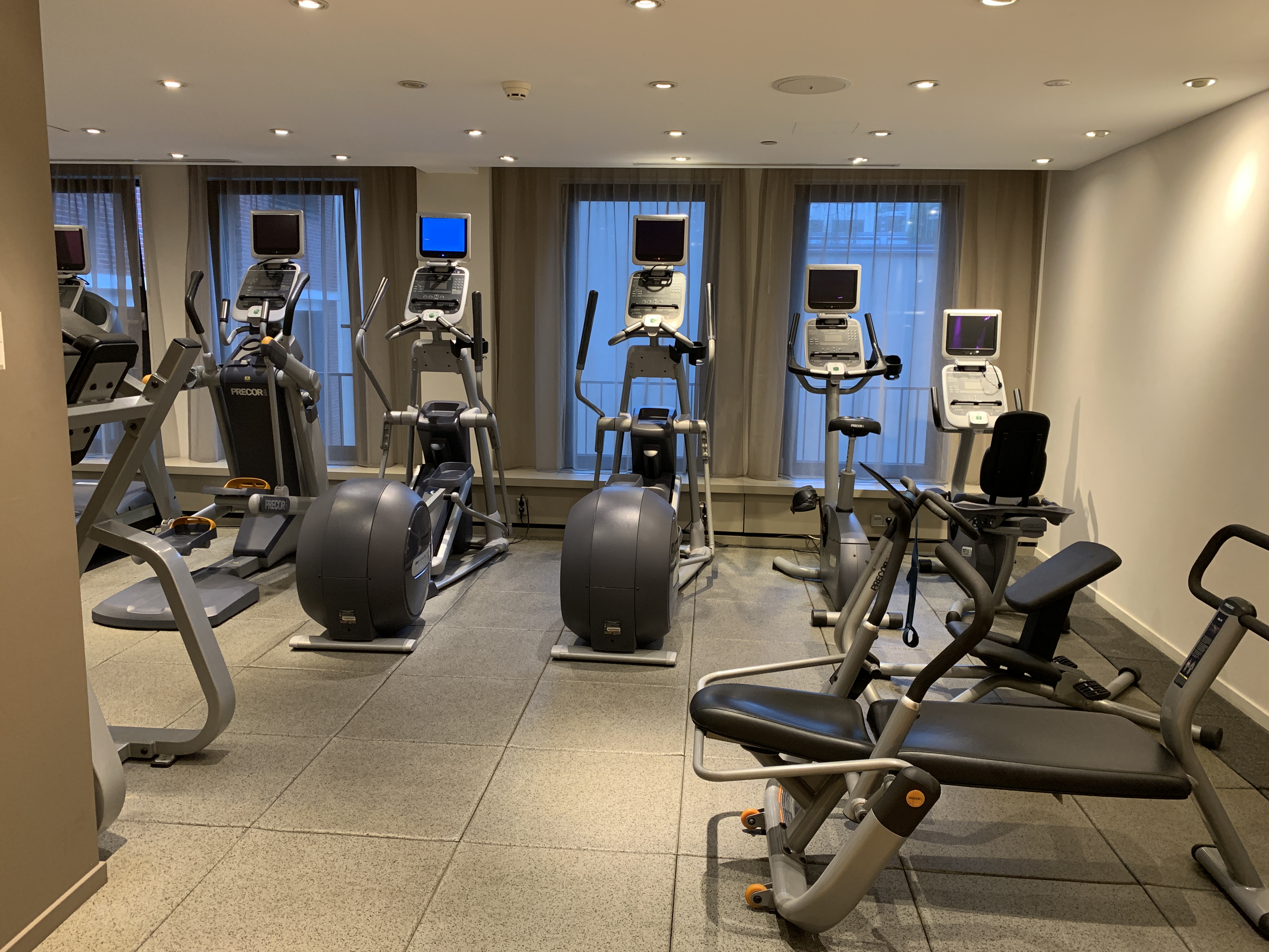 a room with exercise machines and windows