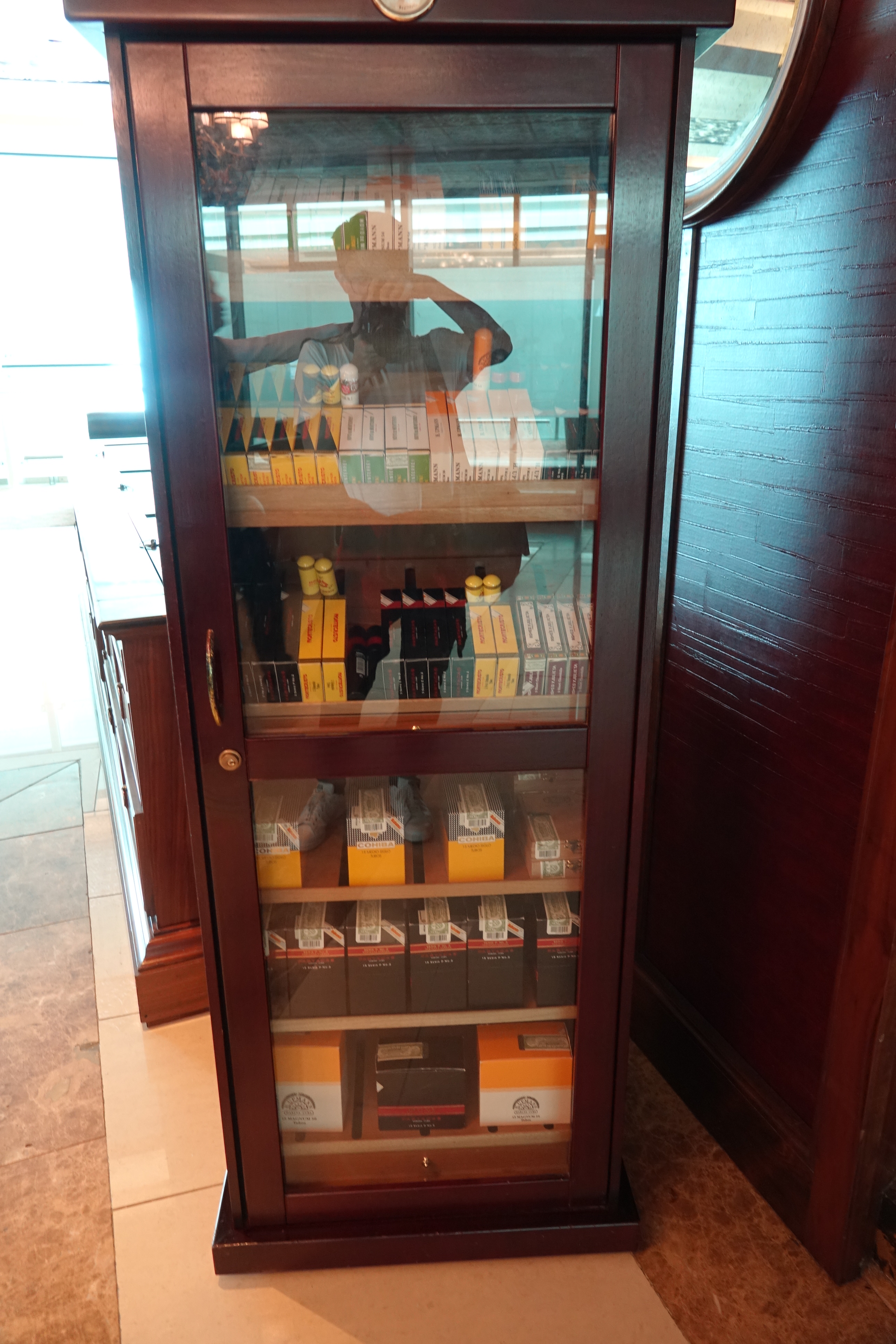 a glass cabinet with a person standing behind it