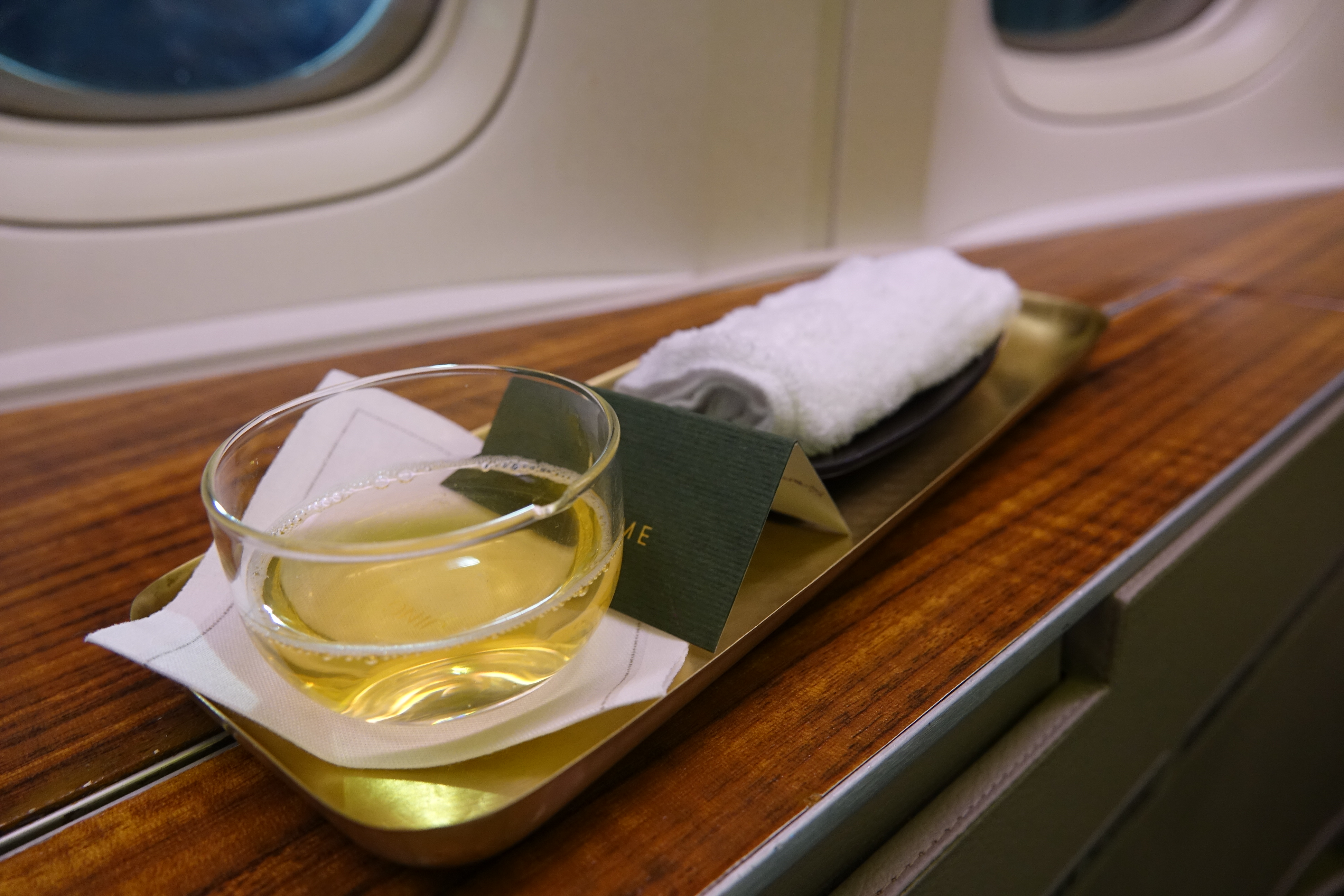 a glass of liquid on a tray on a table