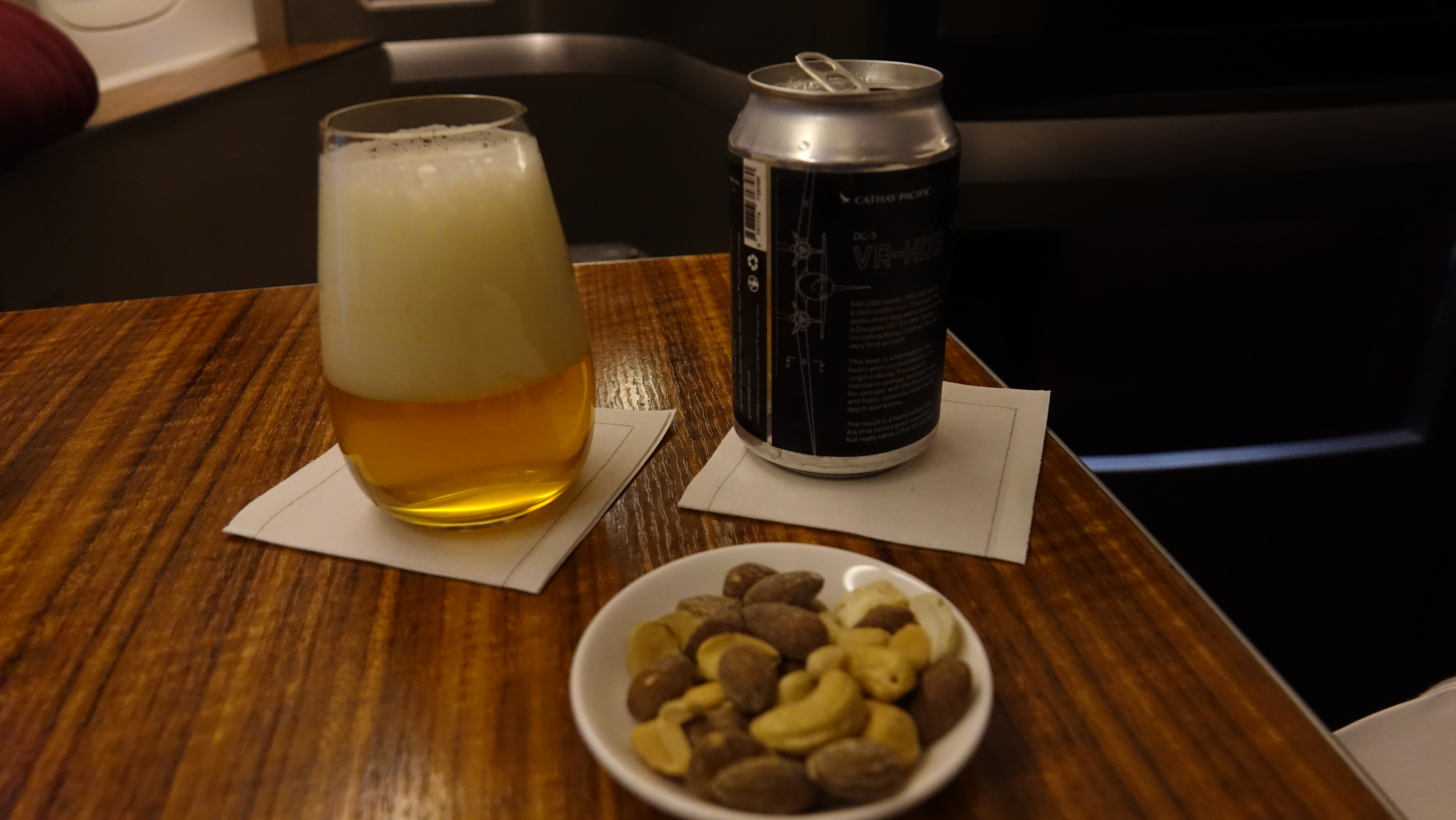 a bowl of nuts and a can of beer on a table