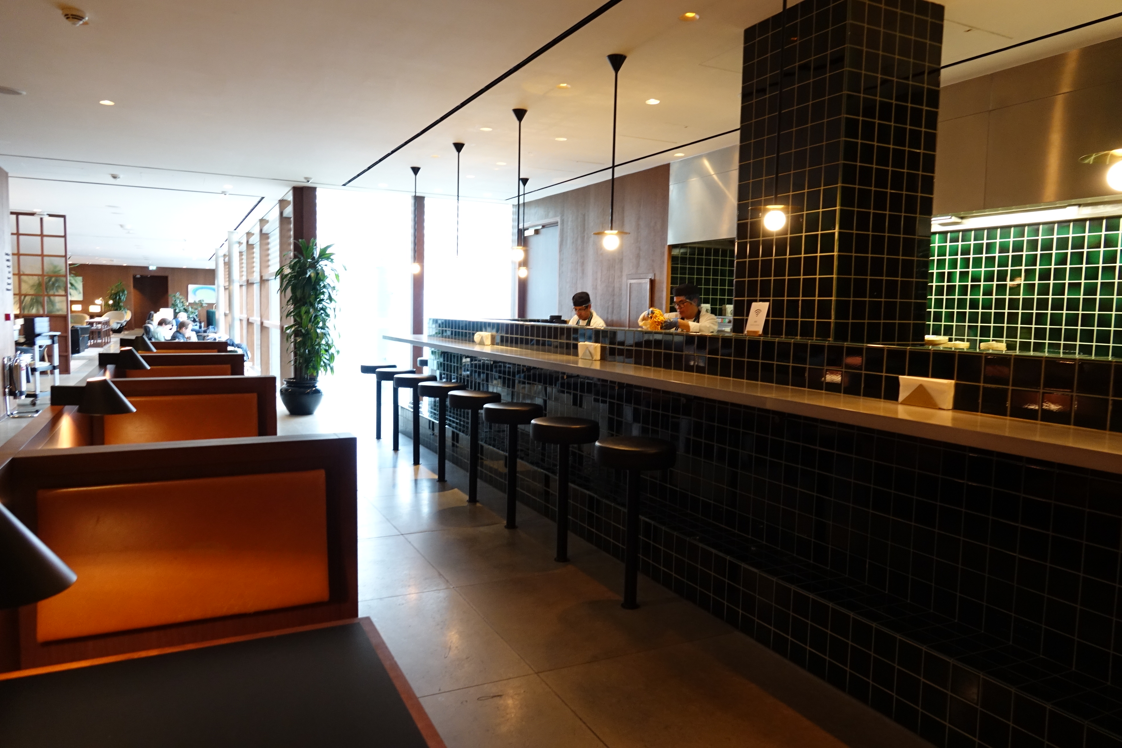 a restaurant with black tile counter and black stools