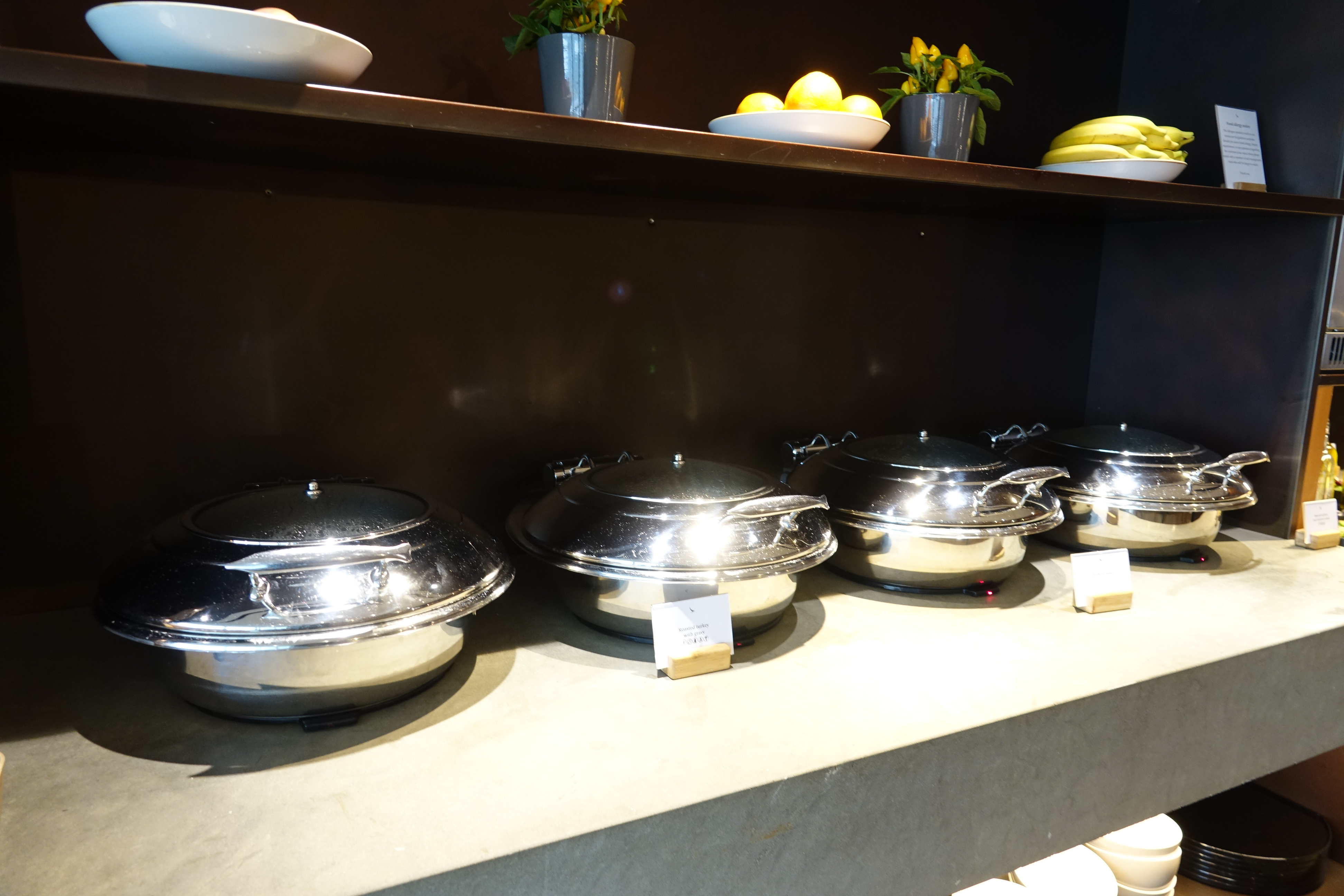 a group of silver pots on a shelf