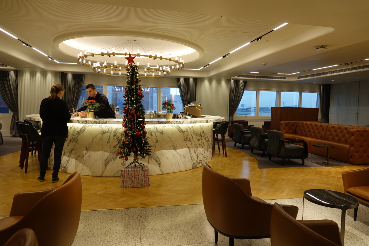 a room with a christmas tree and a man standing behind a counter