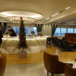 a room with a christmas tree and a man standing behind a counter