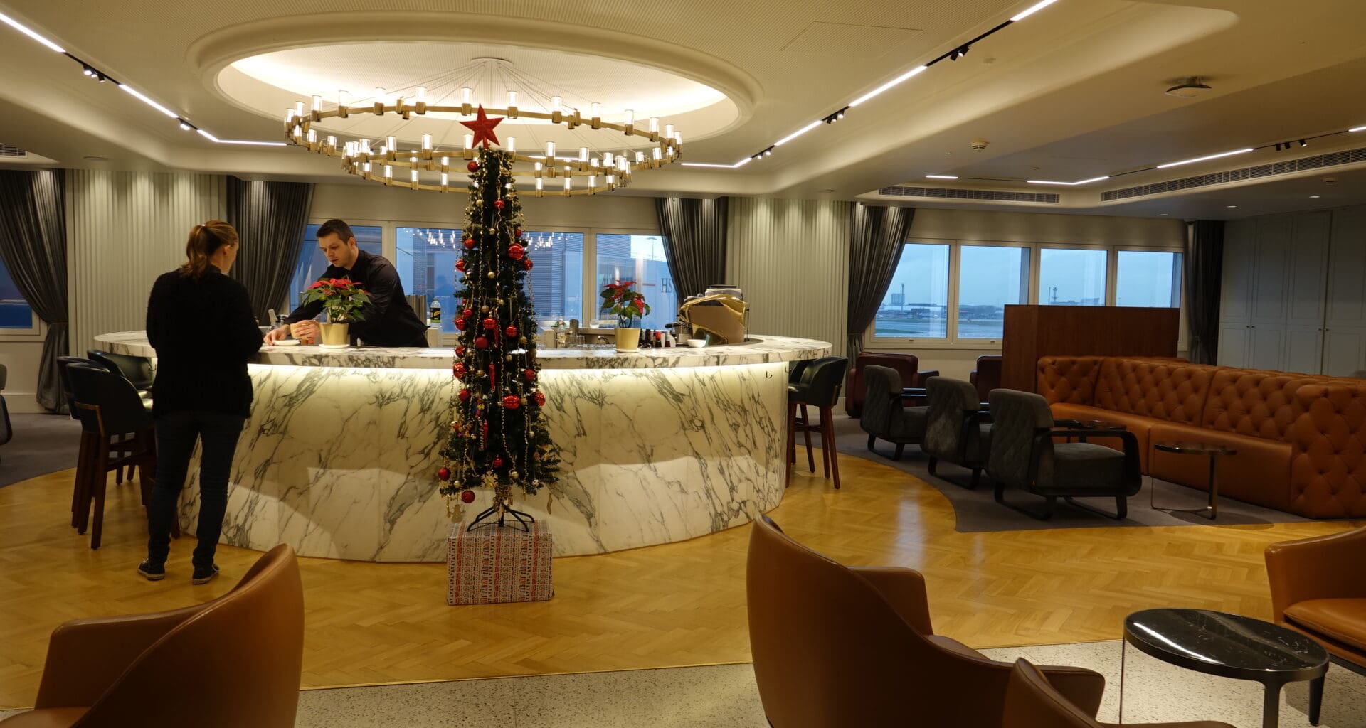 a room with a christmas tree and a man standing behind a counter