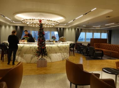 a room with a christmas tree and a man standing behind a counter