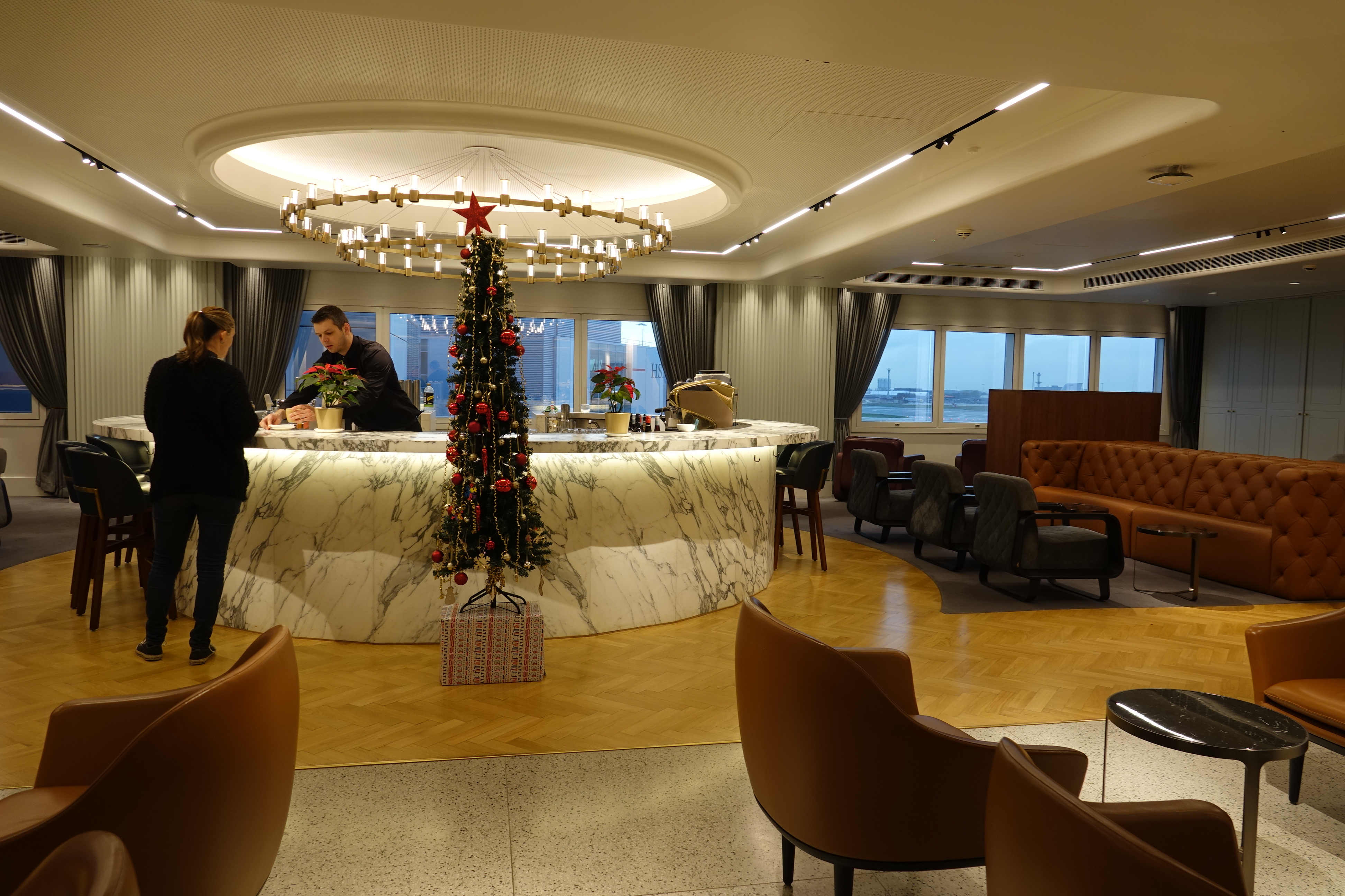 a room with a christmas tree and a man standing behind a counter