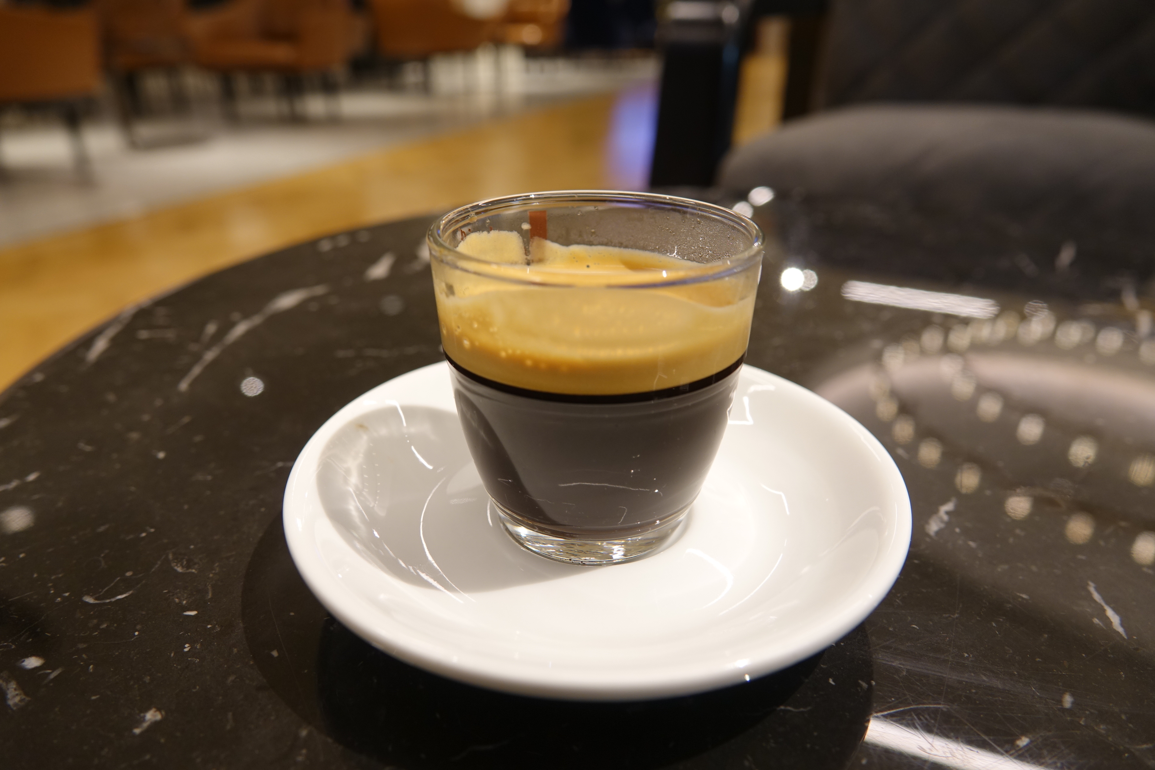 a glass of liquid on a white plate