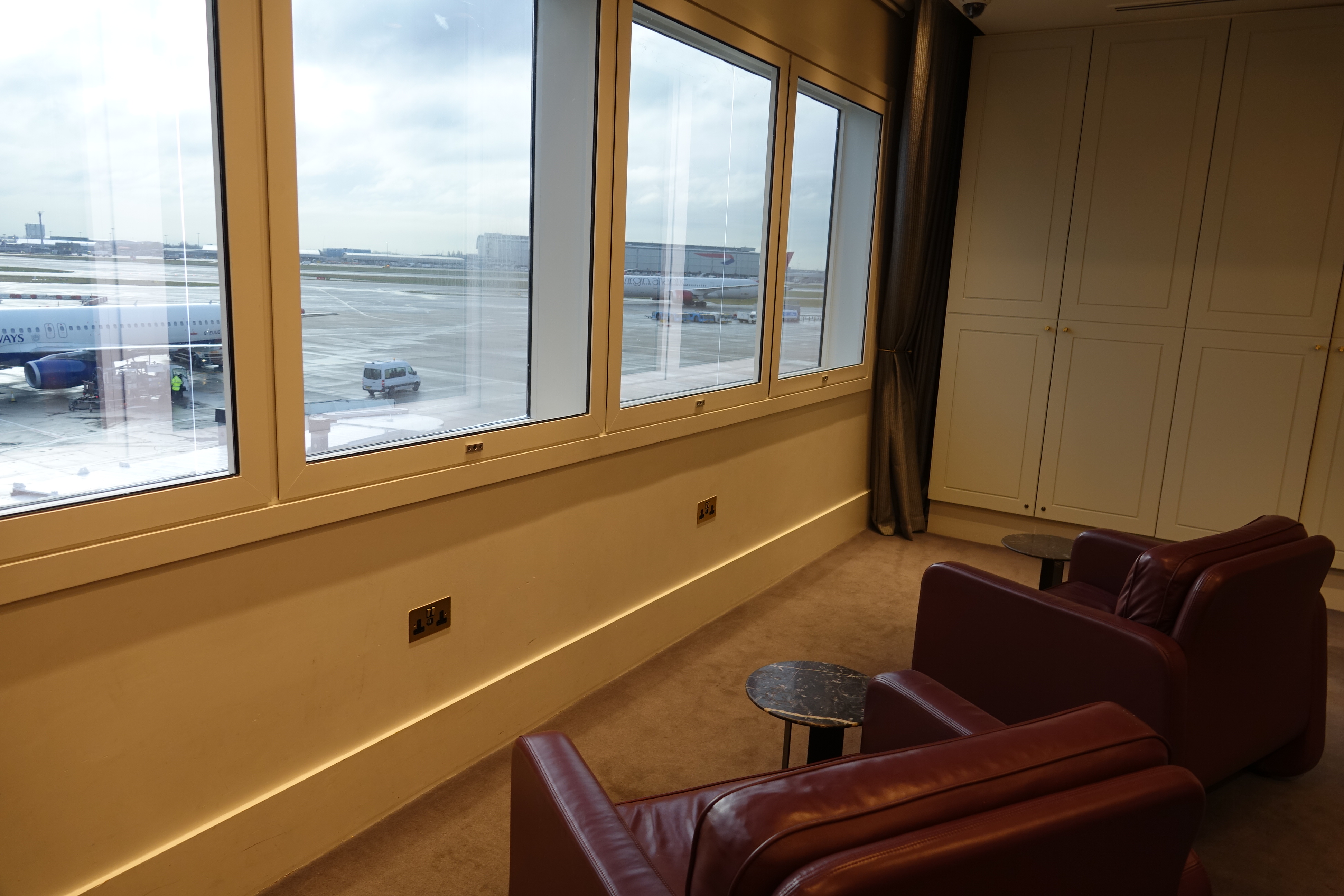 a room with red leather couches and a table and chairs