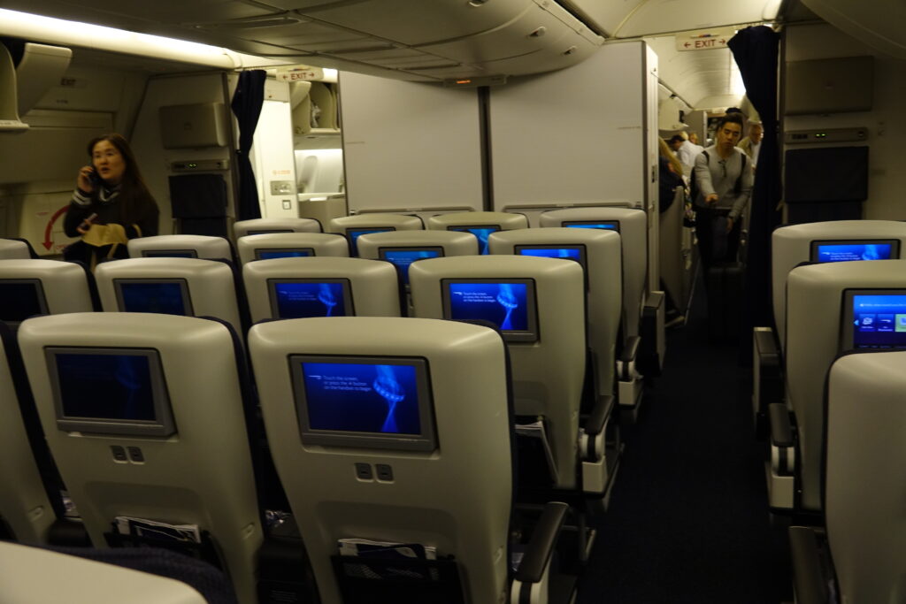 a row of seats with monitors on the back