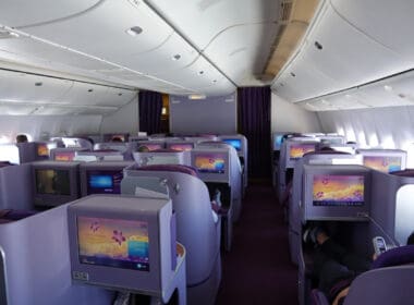 a row of seats with monitors on the back of the plane