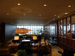 a man sitting in a room with a lamp and a table
