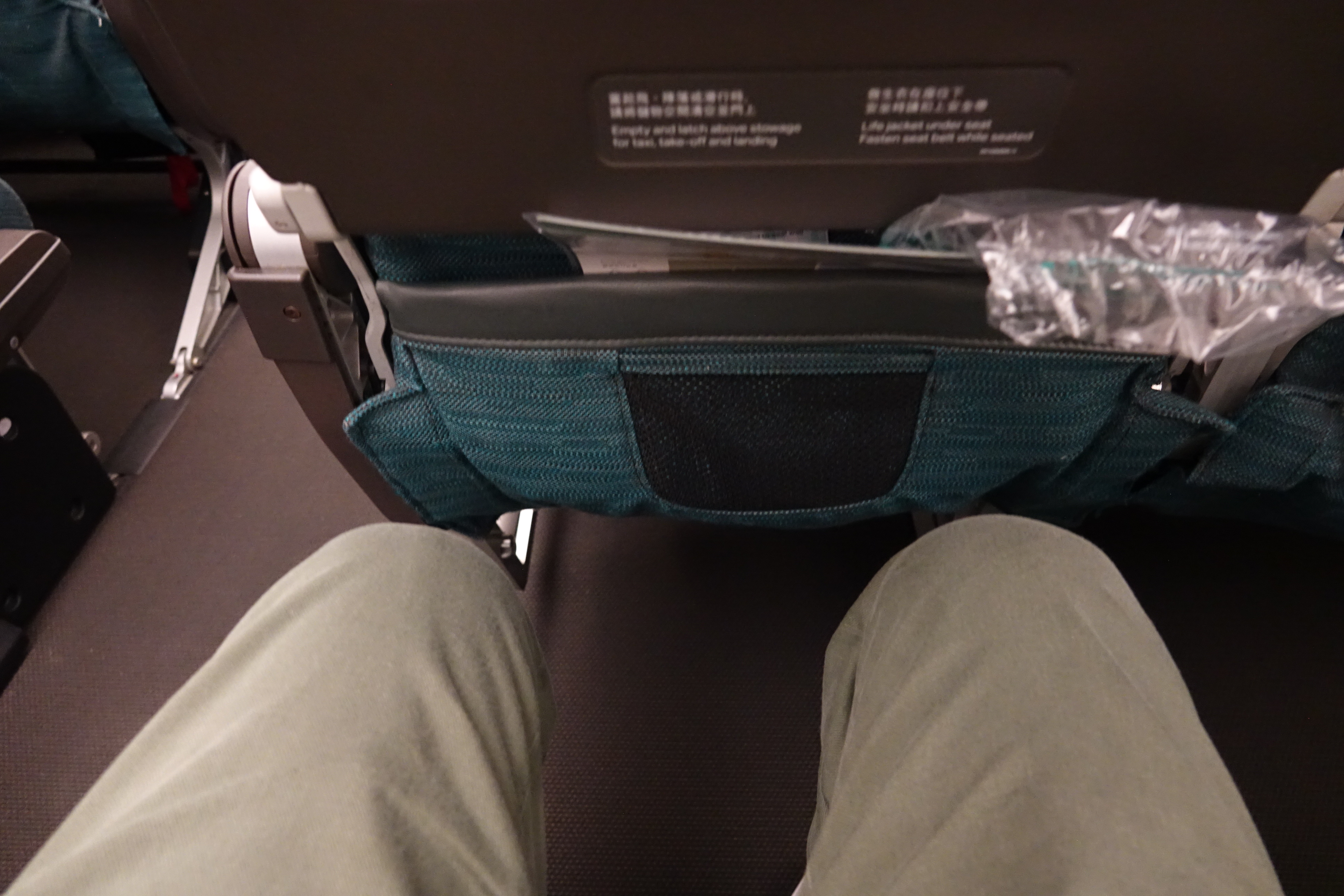 a person's legs in a seat with a pocket in the back