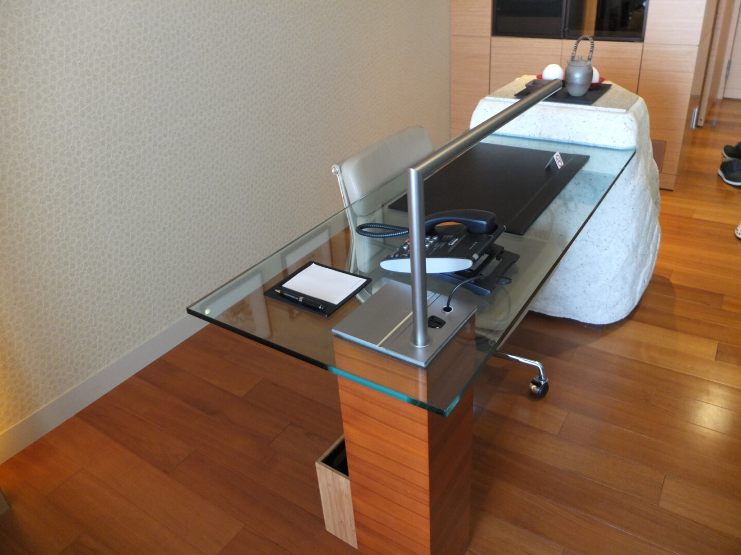 a glass desk with a metal bar on it