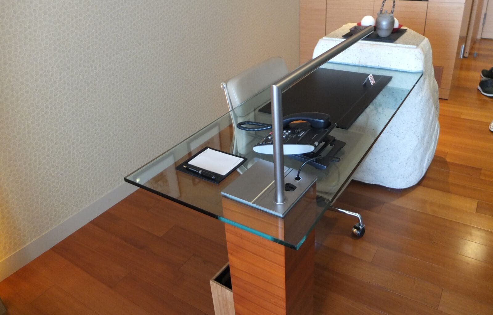 a glass desk with a metal bar on it