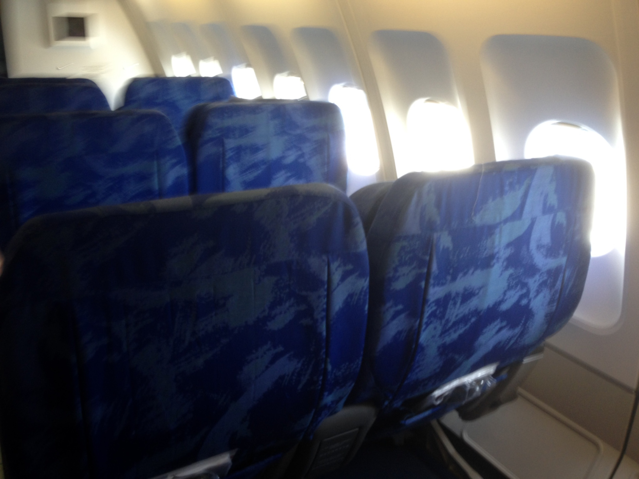 a row of blue seats on an airplane