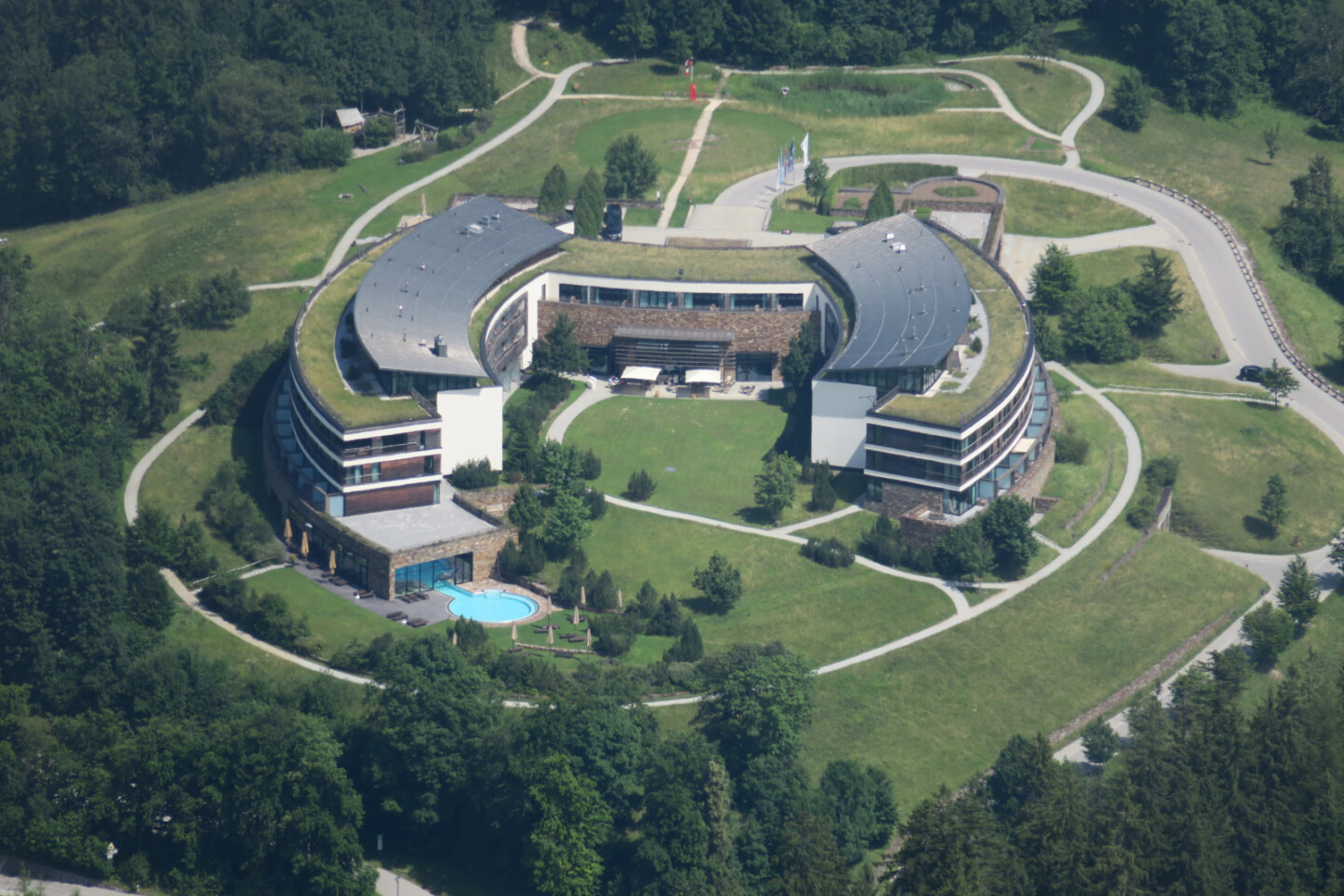 a building with a pool and grass around it