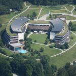 a building with a pool and grass around it