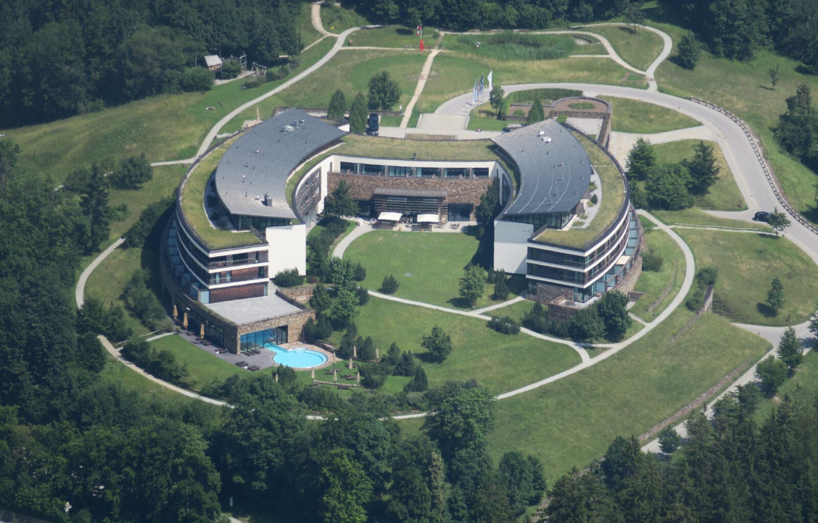 a building with a pool and grass around it