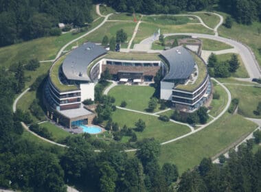 a building with a pool and grass around it
