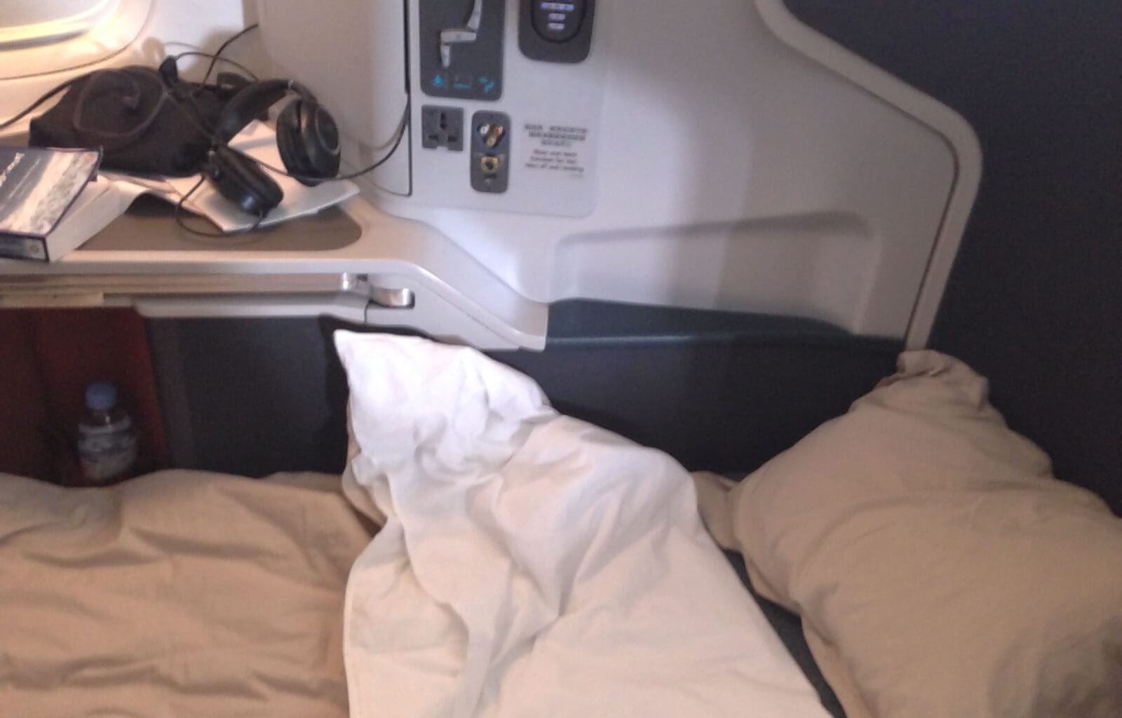 a bed with a pillow and headphones on the side