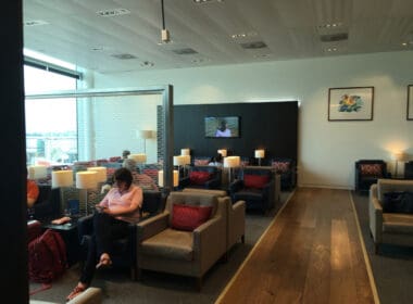 a woman sitting in chairs in a room with a television