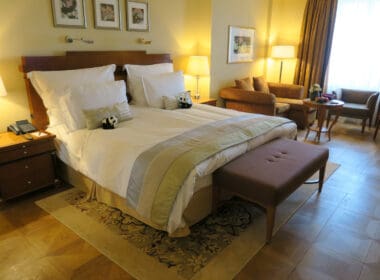 a bed with pillows and a bench in a room