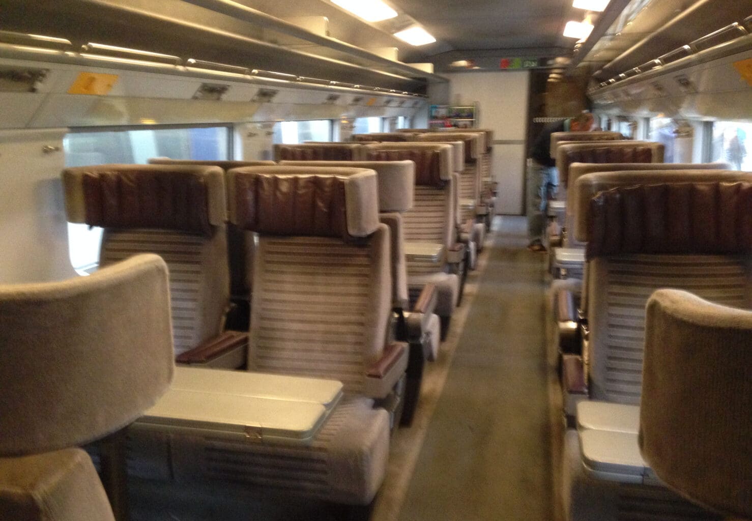 a train with seats and a person standing in the back