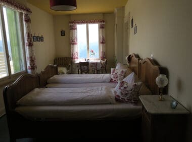 a room with two beds and a table and chairs