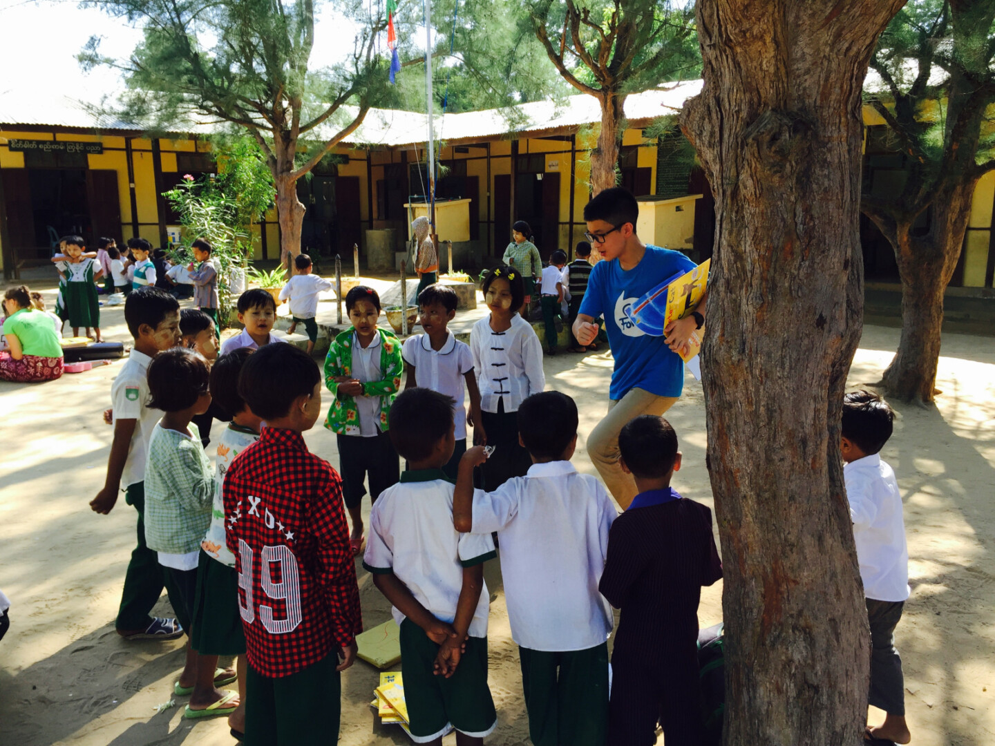 a group of children standing around a tree