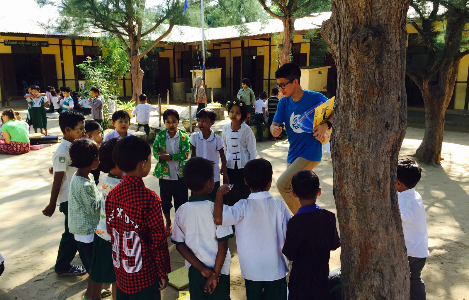 a group of children standing around a tree