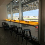 a row of stools in a room with a window