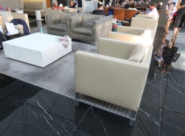 a group of people sitting in a room with chairs and tables