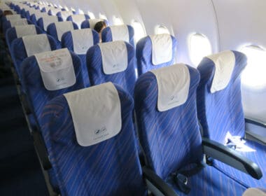 a row of blue seats with white sheets on them