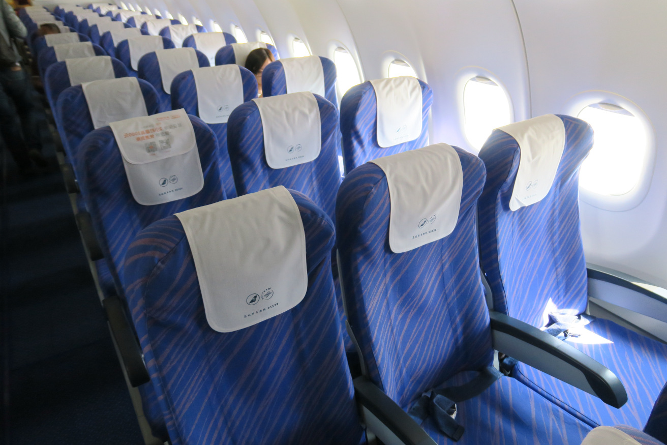 a row of blue seats with white sheets on them