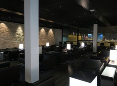 a room with black chairs and a stone wall